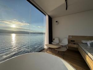 a room with a large window with a view of the water at Selmidis Diamond - Luxury View Cottage & Sauna in Sevan