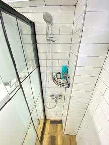 a shower in a bathroom with white tiles at Kadıköy Modern Loft & Equipped Stay in Istanbul