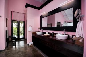 un bagno con tre lavandini e un grande specchio di Kahanda Kanda a Koggala