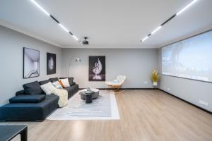 a living room with a black couch and a large screen at 上海柠檬汁民宿 Shanghai lemon juic B&B-Shanghai Lemon Deluxe Room 外滩南京西路步行街 in Shanghai