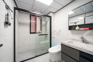 a bathroom with a glass shower and a toilet at 上海柠檬汁民宿 Shanghai lemon juic B&B-Shanghai Lemon Deluxe Room 外滩南京西路步行街 in Shanghai
