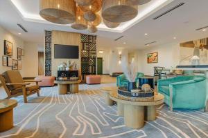 a hotel lobby with furniture and a flat screen tv at Cambria Hotel El Centro - Imperial in El Centro