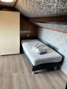 una cama pequeña en una habitación pequeña con una cama cuadrada en Expats House 4 Etten-Leur, en Etten-Leur