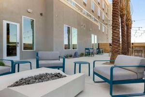 a lobby with chairs and a table and palm trees at Cambria Hotel El Centro - Imperial in El Centro