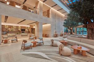 a lobby with tables and chairs in a building at Hilton Gurugram Baani City Centre in Gurgaon