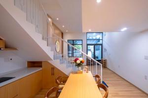 eine Küche und ein Esszimmer mit einem Holztisch und einer Treppe in der Unterkunft Hue House - Zen Gần Aeon Mall Huế in Thôn Trường Giang + 104 Fotos