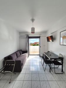 a living room with a couch and a table at Natalie's Hotel in Skala Kefalonias
