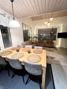 a dining room with a table and chairs and a couch at Kulta Villa, keskellä Vuokattia sisältyy Sauna, ilmainen Pysäköinti, Wi-Fi, 65smartTV, oma pieni piha alue, sopii perheille in Vuokatti +20 photos