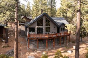 a house with a wrap around deck in the woods at Coyote Moon by AvantStay Cabin WSauna Mins from DT Truckee NorthStar in Truckee