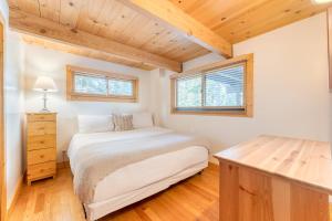 HomewoodにあるTahoe Timber by AvantStay Beach Lake Accessの木製の天井が特徴のベッドルーム1室(ベッド1台付)