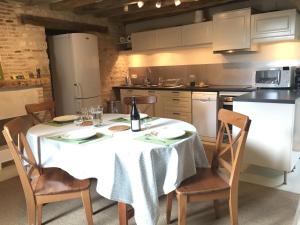 a kitchen with a table with a bottle of wine on it at Un Figuier dans notre Jardin in Beaune-la-Rolande