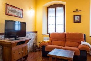 a living room with a couch and a flat screen tv at Casa Rural Villa Calera in Rueda