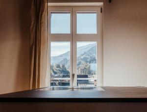a window with a view of a mountain at Hidden Retreats The Alpstyle in Frutigen