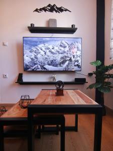 a living room with a table and a television on a wall at Spitaki Kastoria Apartment in Kastoria