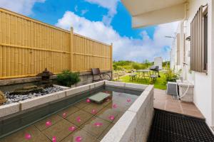 un patio trasero con una piscina con bolas rosas. en BBQ可能 露天風呂付き 麻雀 ビリヤード 卓球も可能な最大12名の一棟貸し KOEI HOUSE in KANNA, en Ginoza