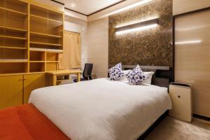 Un dormitorio con una gran cama blanca y un escritorio. en BBQ可能 露天風呂付き 麻雀 ビリヤード 卓球も可能な最大12名の一棟貸し KOEI HOUSE in KANNA, en Ginoza 62 fotos más