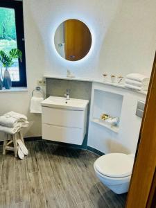 Un baño con lavabo, inodoro y espejo. en Castles Corner Bad Fallingbostel, en Bad Fallingbostel