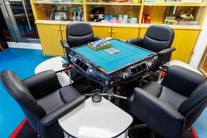 Un grupo de sillas y una mesa en una habitación. en BBQ可能 露天風呂付き 麻雀 ビリヤード 卓球も可能な最大12名の一棟貸し KOEI HOUSE in KANNA, en Ginoza