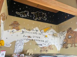 a bedroom with a wall with drawings on it at BEAR FOOT apartment in Yakumo
