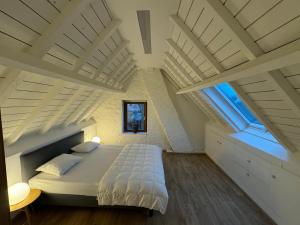 a bedroom with white ceilings and a large bed at De Veldmuis, met mooie speelhoek en speelhuis in Koksijde