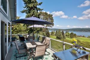 un patio con tavolo, sedie e ombrellone di Fairway Harbor View by AvantStay Outdoor Oasis a Freeland
