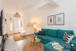 ein Wohnzimmer mit einem blauen Sofa und einem Tisch in der Unterkunft La petite maison de Armação de Pêra By Calyferias in Armação de Pêra