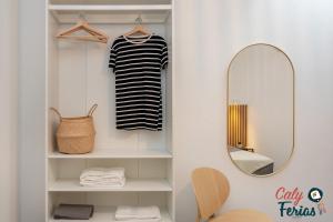 ein Ankleidezimmer mit Spiegel und Regal in der Unterkunft La petite maison de Armação de Pêra By Calyferias in Armação de Pêra