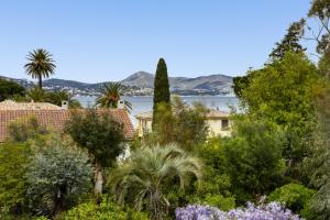 widok na wodę z ogrodu z drzewami w obiekcie 3 Rooms with Sea View Terraces in Peace w Saint-Tropez