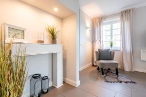 a living room with a chair and a fireplace at Marie - Gartensuite in Archsum