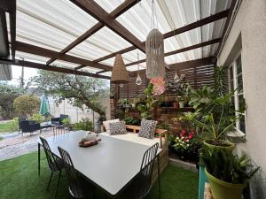 a patio with a white table and some plants at La Casetta, Garden Retreat in Cape Town
