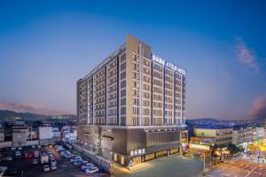 a tall building in a city with a parking lot at Atour Hotel Tengchong Wenxing Building in Tengchong