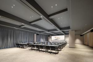 une salle de conférence avec des tables, des chaises et un écran dans l'établissement Atour Hotel Tengchong Wenxing Building, à Tengchong