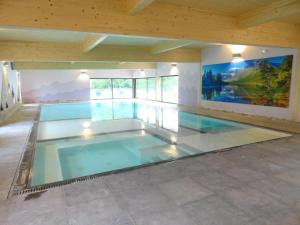 a swimming pool in a house with a wooden ceiling at Chalet Confort Aloya in Ranspach