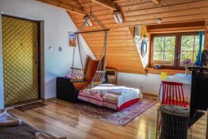 een slaapkamer met een hangmat in een houten huis bij Askaro, Kazimierz Dolny in Kazimierz Dolny