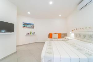 Un dormitorio blanco con una cama y un televisor de pantalla plana. en La Stampa Room, en Olbia