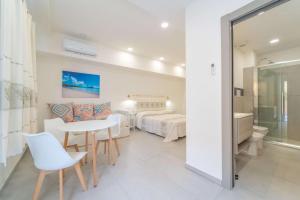 Un dormitorio con una cama y una mesa y sillas. en La Stampa Room, en Olbia