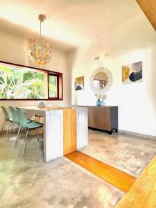 a dining room with a table and green chairs at Six Boutique Collection in Mannārgudi