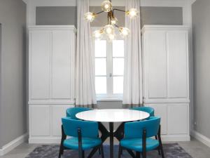 a dining room with a white table and blue chairs at DRAGO d' ORO SUITES in Florence