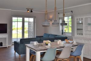 a living room with a table and a blue couch at Reethaus 1A in Staberdorf