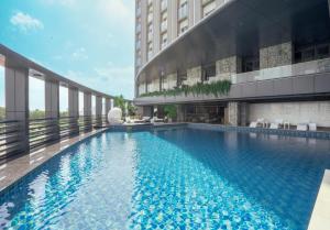 头顿The Malibu Hotel的建筑物前有一个大型游泳池。