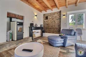 a living room with a blue chair and a fireplace at Les camelias in Plouézec