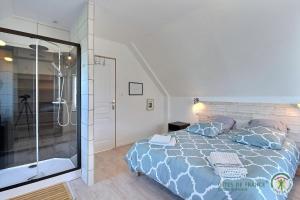 a bedroom with a bed and a glass shower at Les camelias in Plouézec