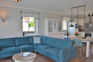 a living room with a blue couch and a table at Reethaus 3A in Staberdorf