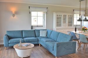 a living room with a blue couch and a table at Reethaus 3A in Staberdorf