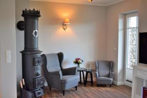 a living room with two chairs and a wood stove at Reethaus 3A in Staberdorf +39 photos