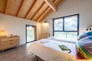 a bedroom with a bed and a dresser and windows at Chalet Rossanaz in La Motte-en-Beauges +28 photos