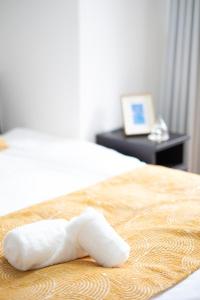 a piece of white towel laying on a bed at The Peak Tengachaya in Osaka
