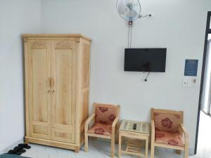 モクチャウにあるThái Sơn Hotel Mộc Châuの椅子2脚、テレビ、キャビネットが備わる客室です。 +4枚の写真