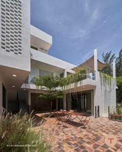 a house with a courtyard with chairs and a building at Nghỉ dưỡng tại TERRA VILLA in Vung Tau