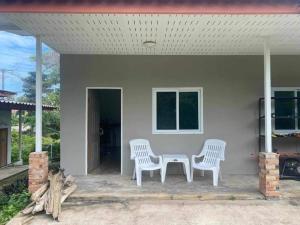 two white chairs and a table on a porch at Near & Far in Ko Lanta
